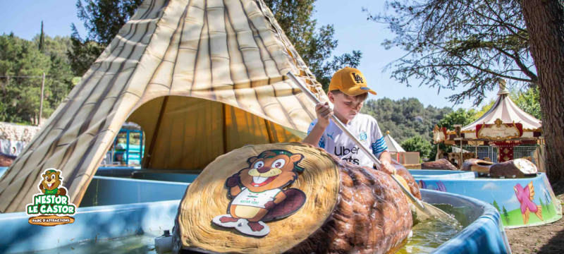 Enfant sur un canoé au parc d'attraction Nestor le Castor 