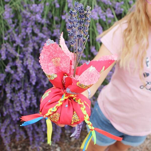 Un jeune visiteur tenant dans la main un sachet de lavande personalisé 